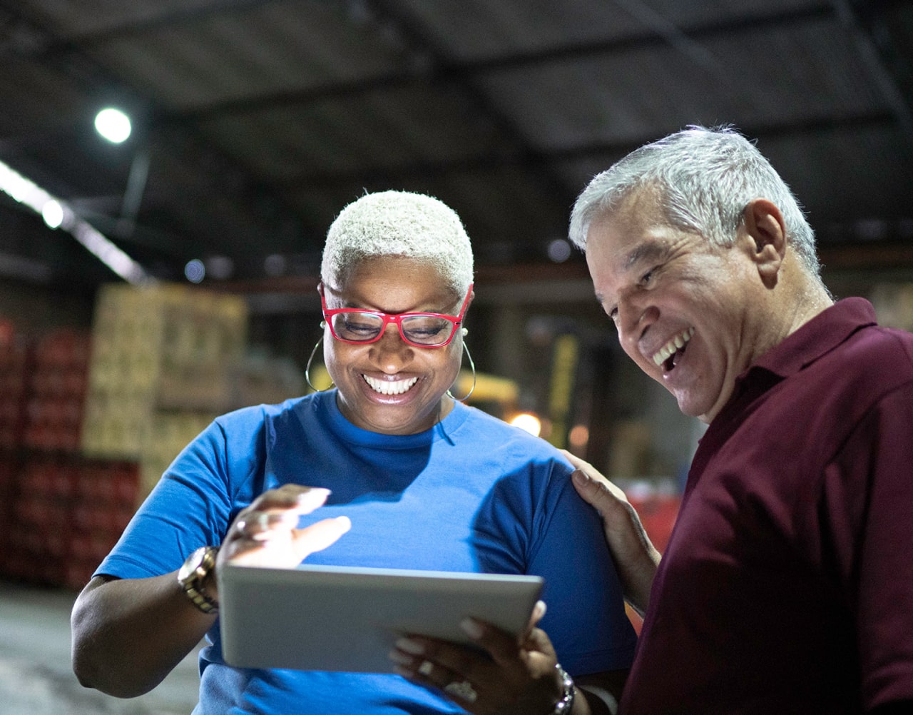 Two warehouse workers smiling